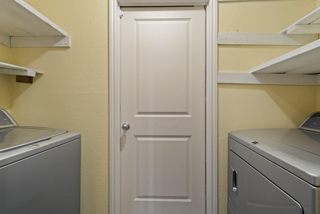 clothes washing area with washer and clothes dryer