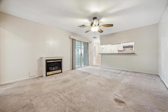 unfurnished living room with light colored carpet and ceiling fan