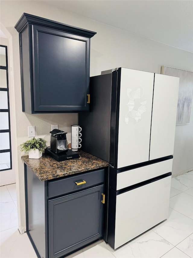 kitchen with white fridge and dark stone counters