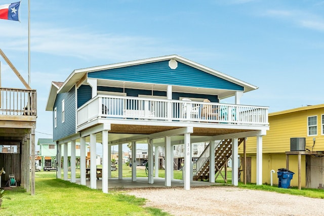 back of house featuring central AC, a carport, and a lawn