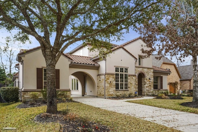 mediterranean / spanish house featuring a front lawn