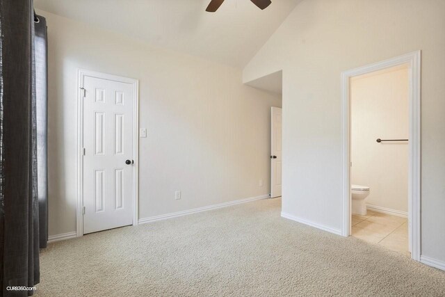 unfurnished bedroom with ensuite bath, lofted ceiling, and light carpet