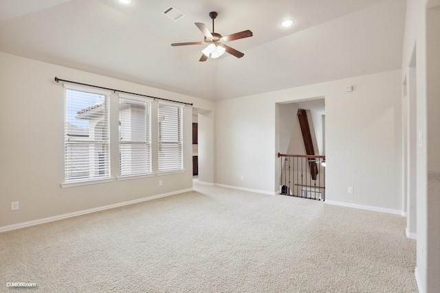 empty room with vaulted ceiling, ceiling fan, and carpet flooring