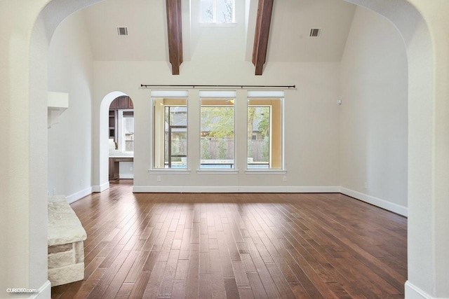 unfurnished living room featuring dark wood-type flooring, beam ceiling, and high vaulted ceiling