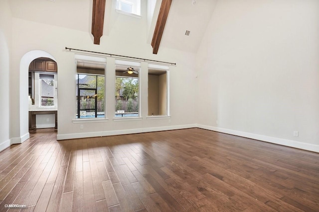 empty room featuring ceiling fan, dark hardwood / wood-style flooring, high vaulted ceiling, and beam ceiling