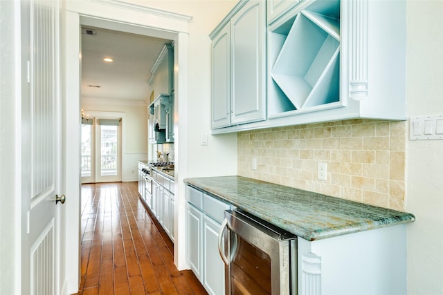 kitchen with stone counters, dark hardwood / wood-style floors, tasteful backsplash, beverage cooler, and ornamental molding