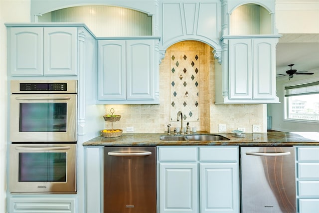 kitchen with sink, white cabinetry, backsplash, stainless steel appliances, and dark stone counters