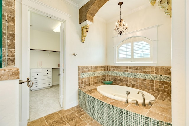 bathroom featuring tiled tub, ornamental molding, and an inviting chandelier