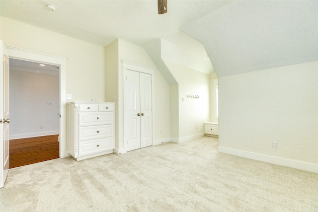 bonus room with light carpet and vaulted ceiling