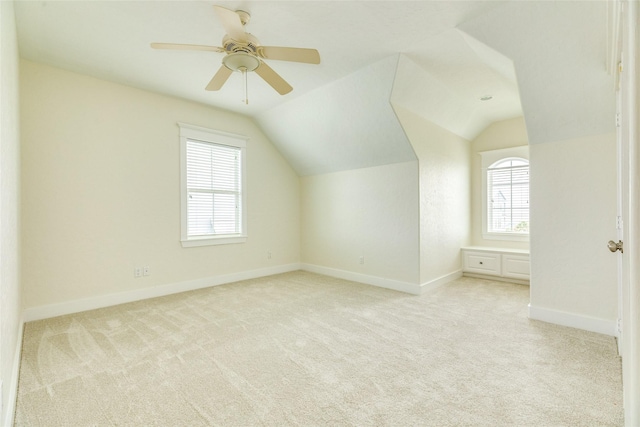 additional living space with ceiling fan, lofted ceiling, and light carpet