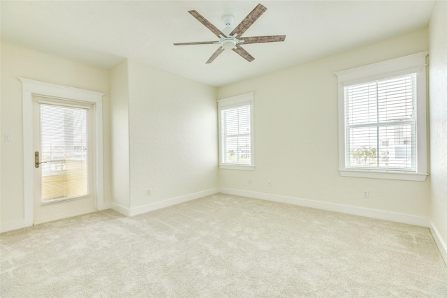 unfurnished room with light colored carpet and ceiling fan