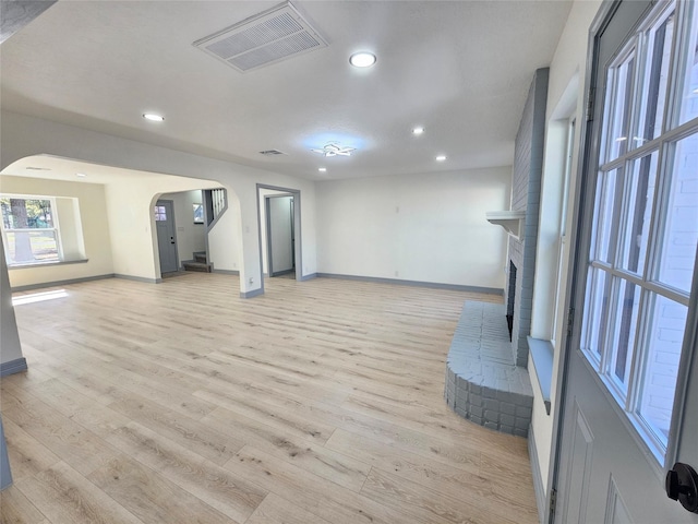 unfurnished living room featuring light hardwood / wood-style flooring and a fireplace