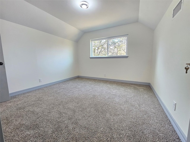 additional living space featuring vaulted ceiling and carpet flooring