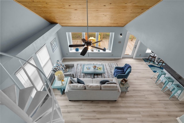 living room featuring wood ceiling, ceiling fan, light hardwood / wood-style flooring, and a high ceiling