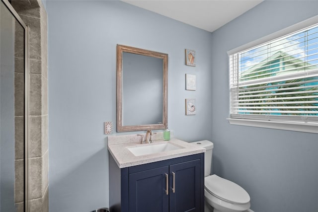 bathroom featuring vanity, toilet, and an enclosed shower