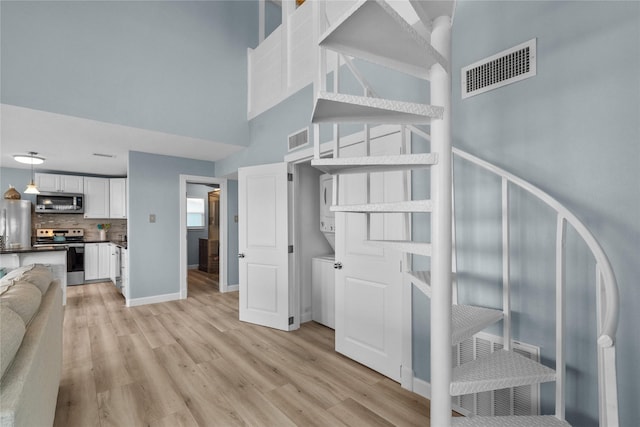 stairway featuring wood-type flooring and a high ceiling