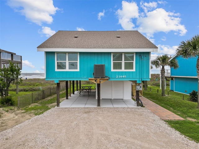 back of property with a carport and a water view