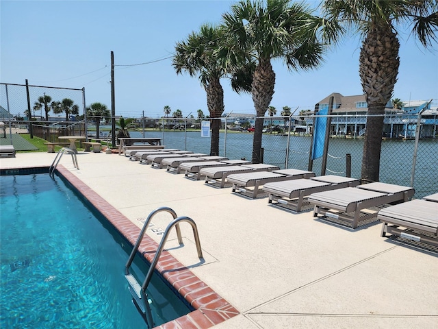 view of pool featuring a patio and a water view