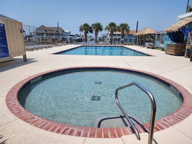 view of swimming pool featuring a gazebo, a community hot tub, and a patio