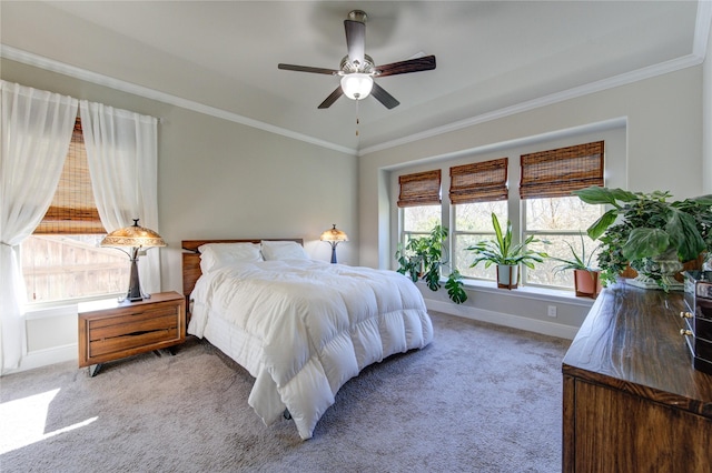 carpeted bedroom with ceiling fan, ornamental molding, and baseboards