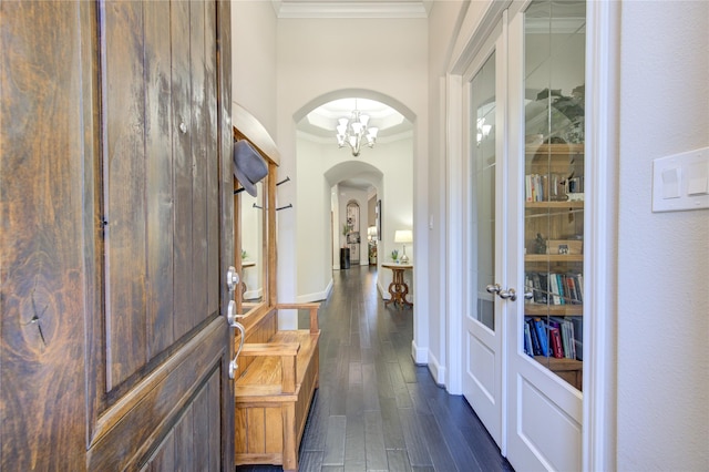 corridor with dark wood-style floors, arched walkways, crown molding, and baseboards