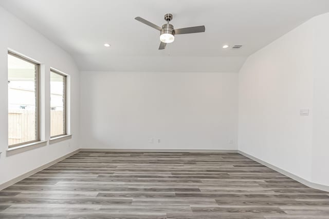 empty room featuring hardwood / wood-style flooring, ceiling fan, and lofted ceiling