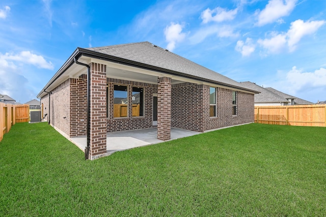 rear view of property featuring a yard and a patio