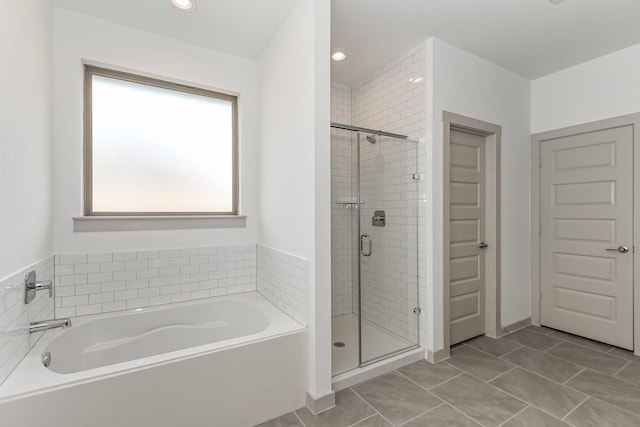 bathroom featuring tile patterned flooring and separate shower and tub