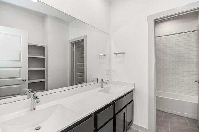 bathroom with tile patterned flooring, vanity, and tiled shower / bath