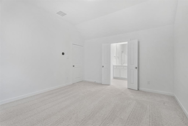 carpeted empty room with lofted ceiling