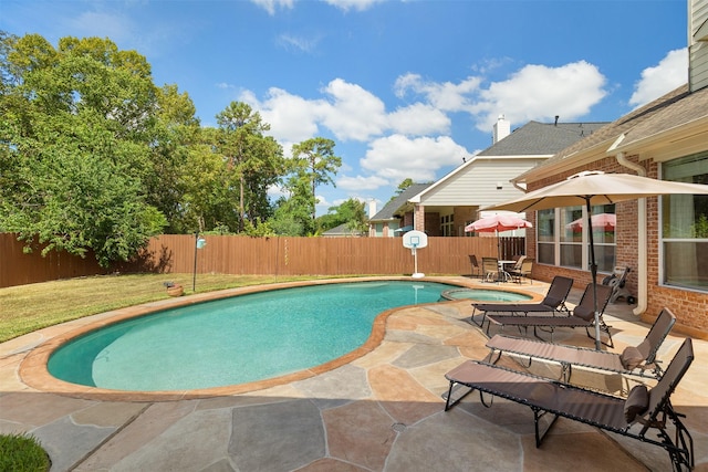 view of pool featuring a patio, a fenced backyard, and a pool with connected hot tub