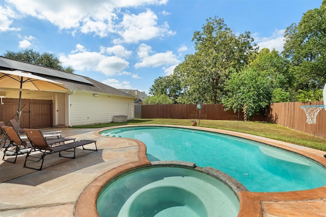 view of swimming pool featuring a patio, a yard, a fenced backyard, and a pool with connected hot tub