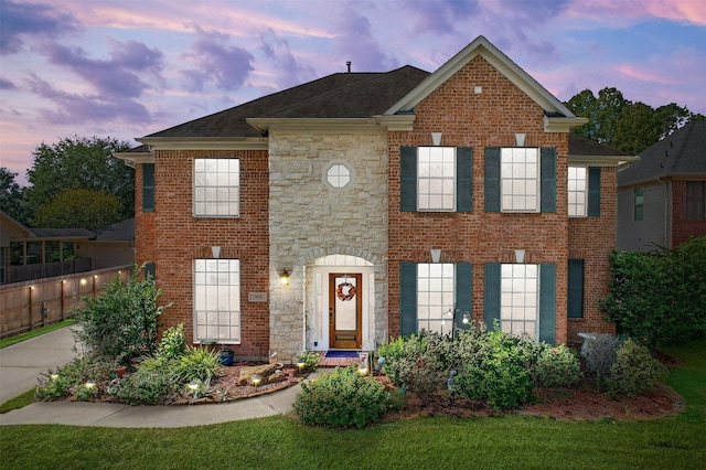 view of front of home featuring stone siding, brick siding, and a shingled roof