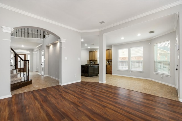 unfurnished living room with wood finished floors, decorative columns, arched walkways, ornamental molding, and stairs