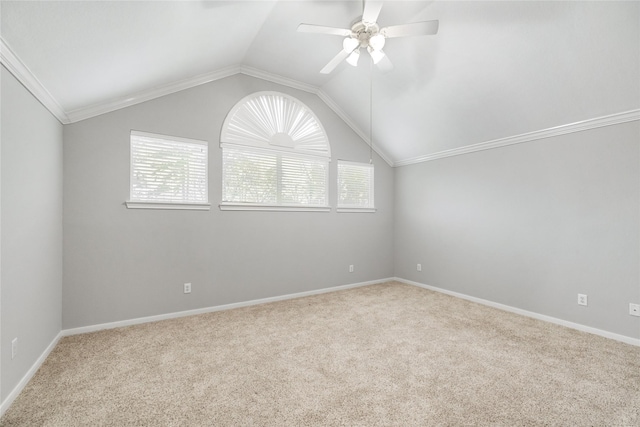 carpeted spare room with baseboards, lofted ceiling, ornamental molding, and a ceiling fan