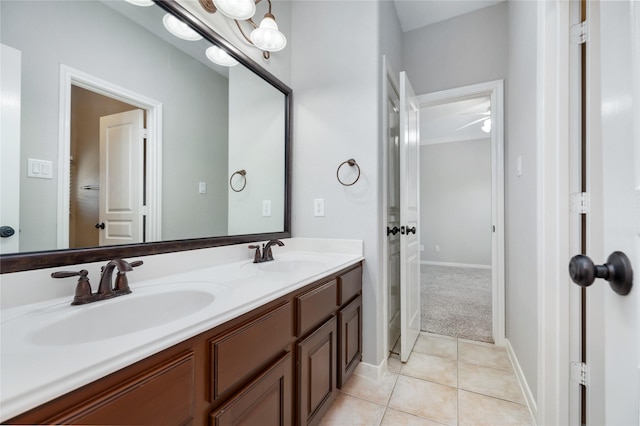 bathroom featuring a sink, baseboards, double vanity, and tile patterned floors