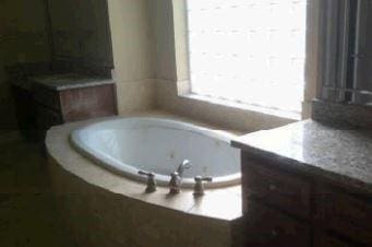 bathroom featuring vanity and tiled bath