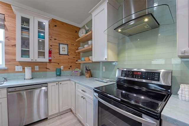 kitchen featuring white cabinetry, appliances with stainless steel finishes, island range hood, and light stone counters