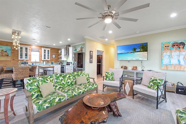 living room with crown molding, light hardwood / wood-style flooring, and ceiling fan