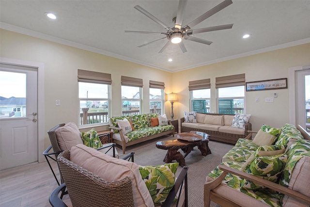 living room featuring ceiling fan, ornamental molding, light hardwood / wood-style floors, and a wealth of natural light