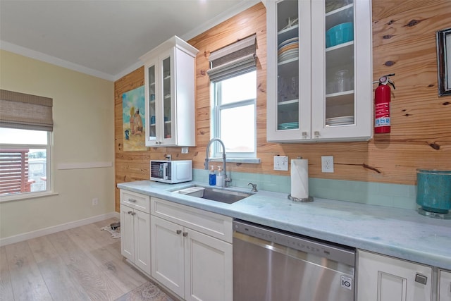 kitchen featuring sink, backsplash, white cabinets, stainless steel dishwasher, and light hardwood / wood-style floors