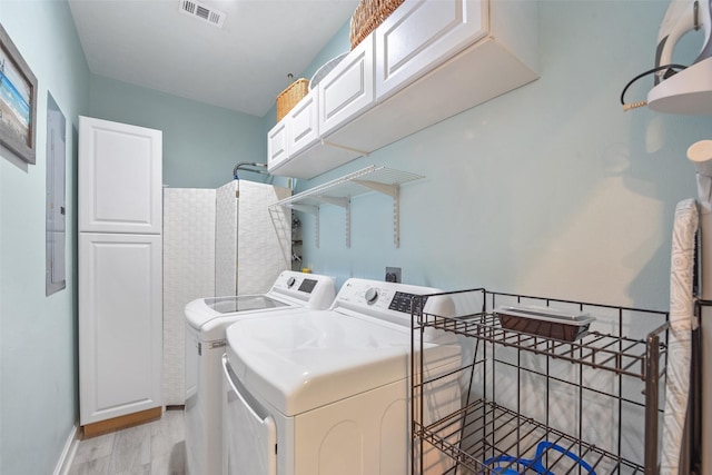 laundry area with cabinets, independent washer and dryer, and light wood-type flooring