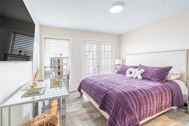 bedroom featuring access to exterior, hardwood / wood-style flooring, and french doors