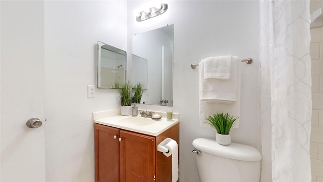 bathroom with vanity, a shower with shower curtain, and toilet