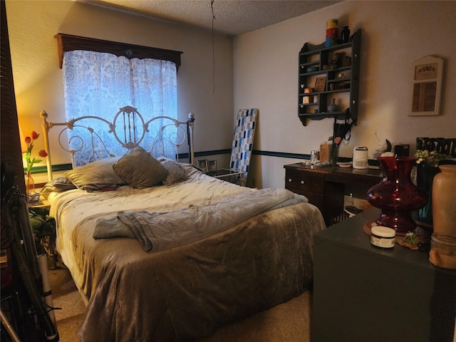 bedroom featuring a textured ceiling and carpet flooring