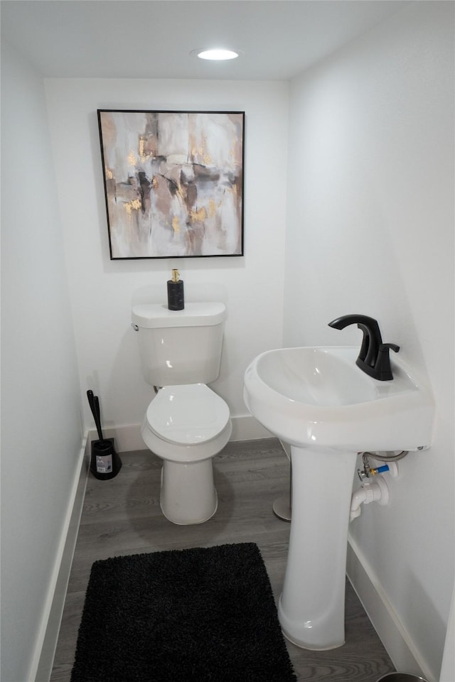 bathroom with hardwood / wood-style floors and toilet