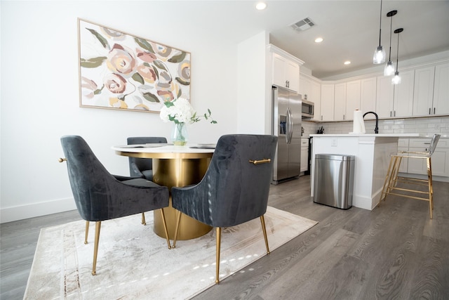 dining room featuring sink and hardwood / wood-style flooring