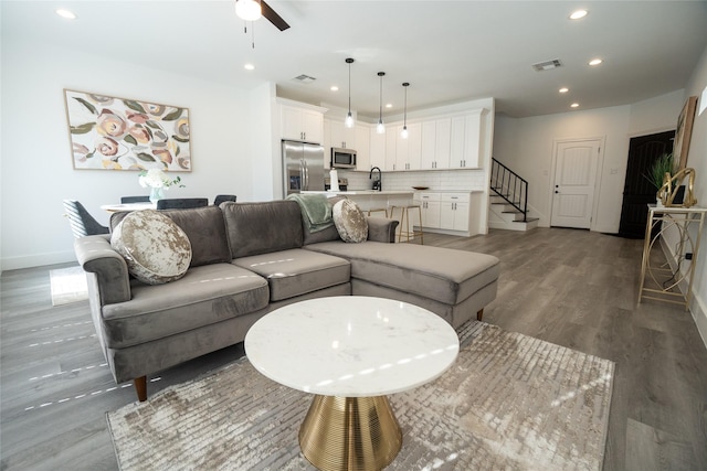 living room featuring sink, hardwood / wood-style floors, and ceiling fan