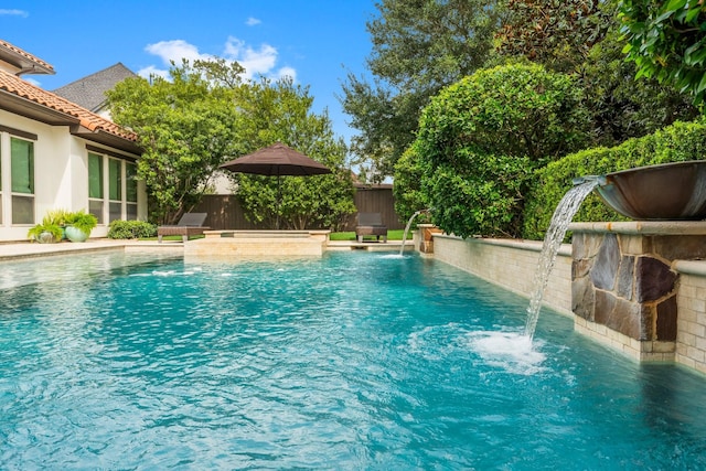 view of pool featuring a fenced backyard, a fenced in pool, and a hot tub