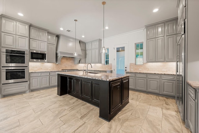 kitchen featuring stainless steel appliances, custom range hood, a sink, and gray cabinetry